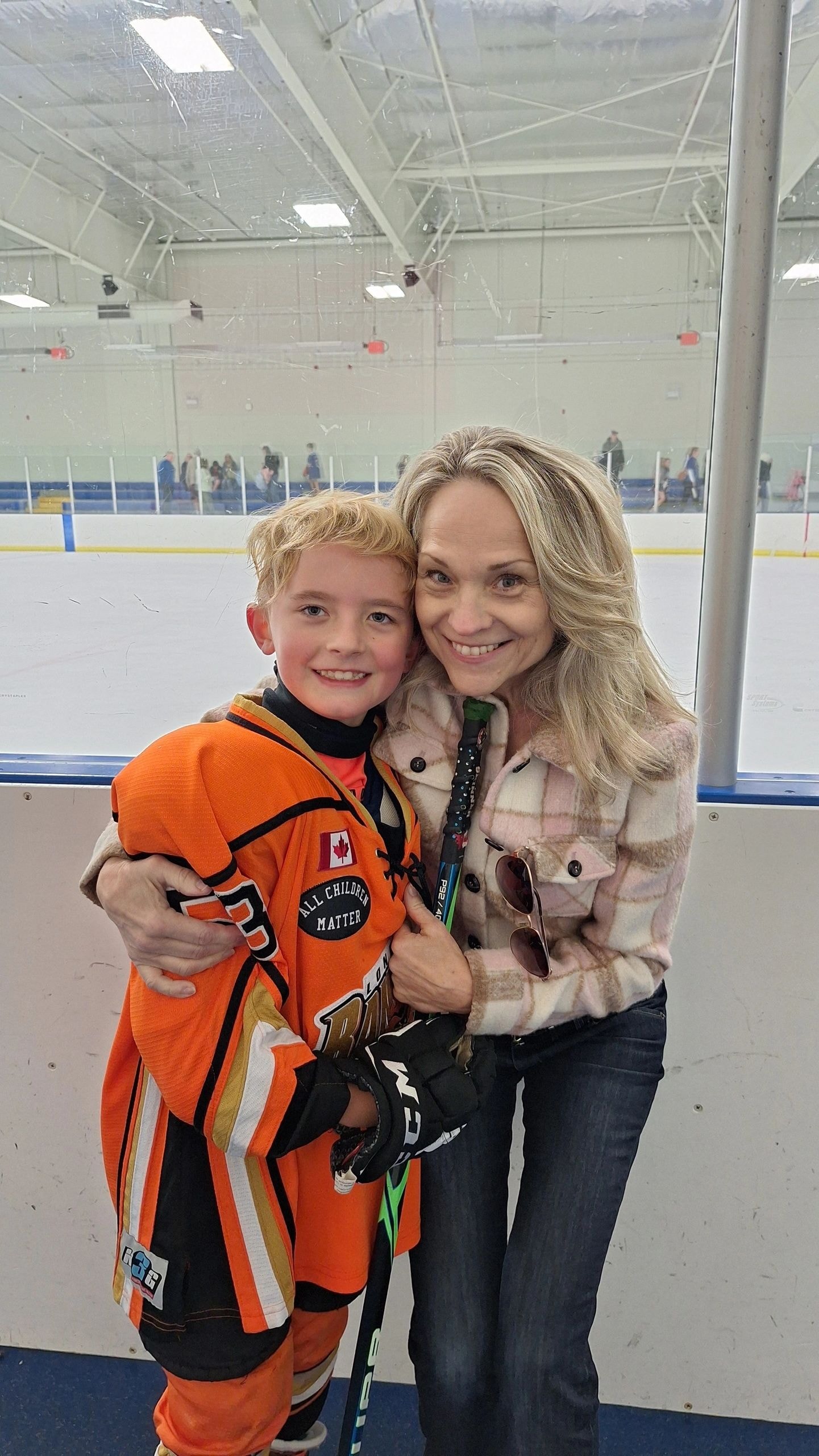 Joanne with Wesley, a young hockey player, at the ice rink