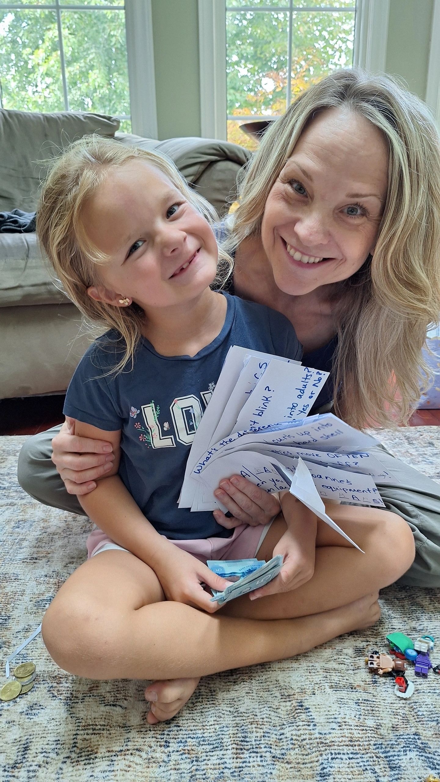 Joanne with young girl Bea holding handwritten notes on the floor