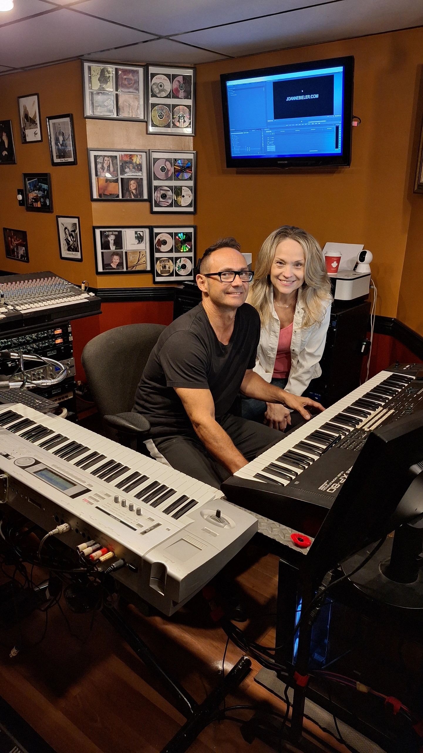 Joanne and Tony smiling together at music studio keyboards