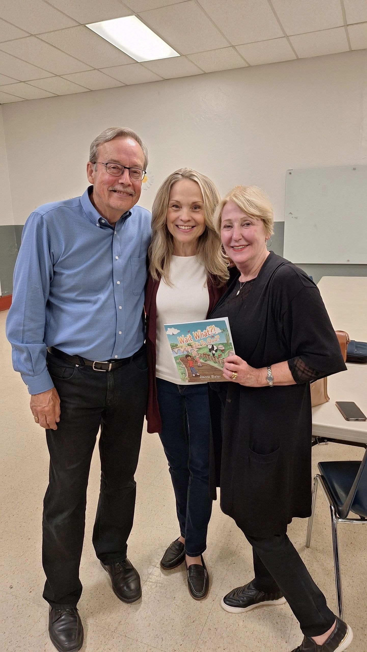 Joanne with couple holding book at Sisters of Life prayer night at St. Peter's Church