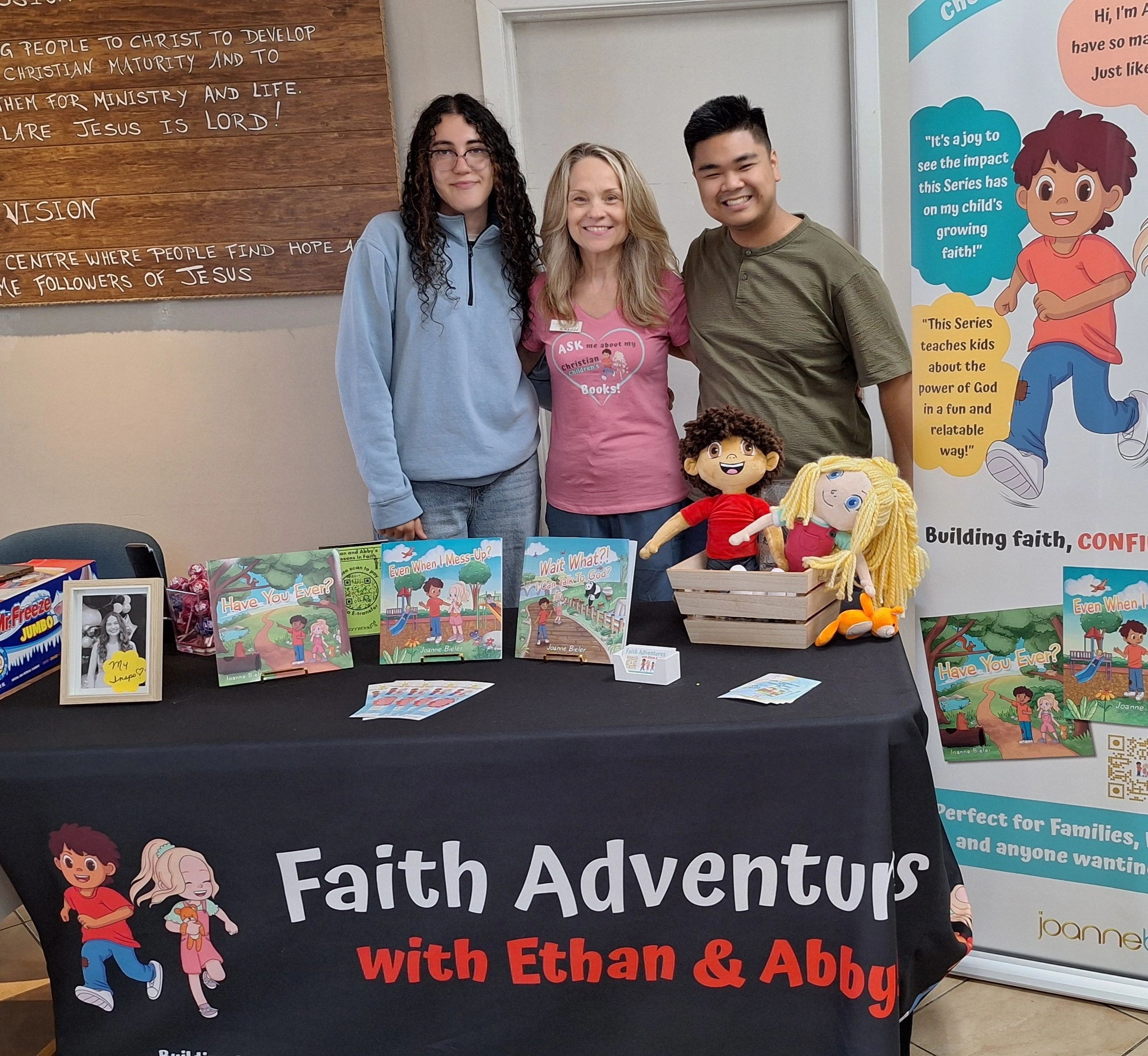 Joanne with Rebecca and Phil at Faith Adventures book table at VBS Christ For Life Church