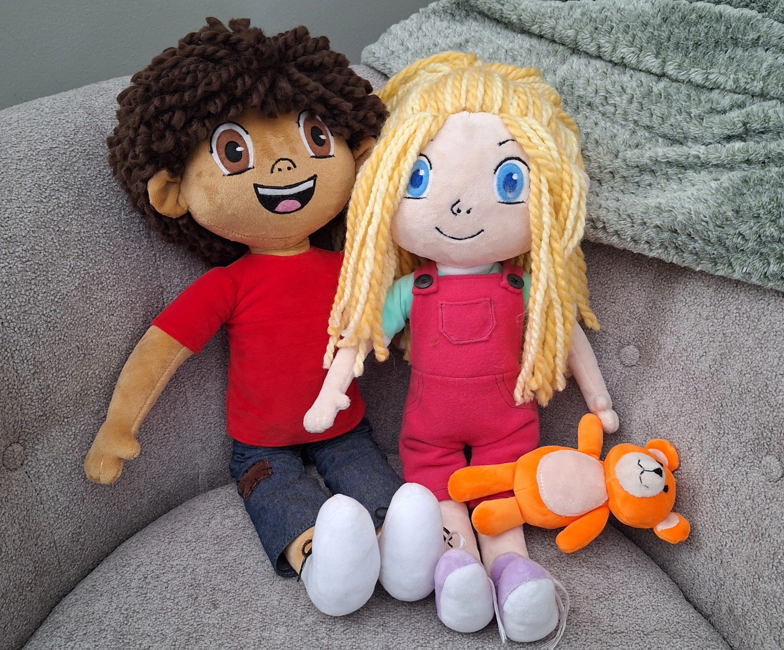 Ethan and Abby plush dolls with teddy bear sitting on a couch