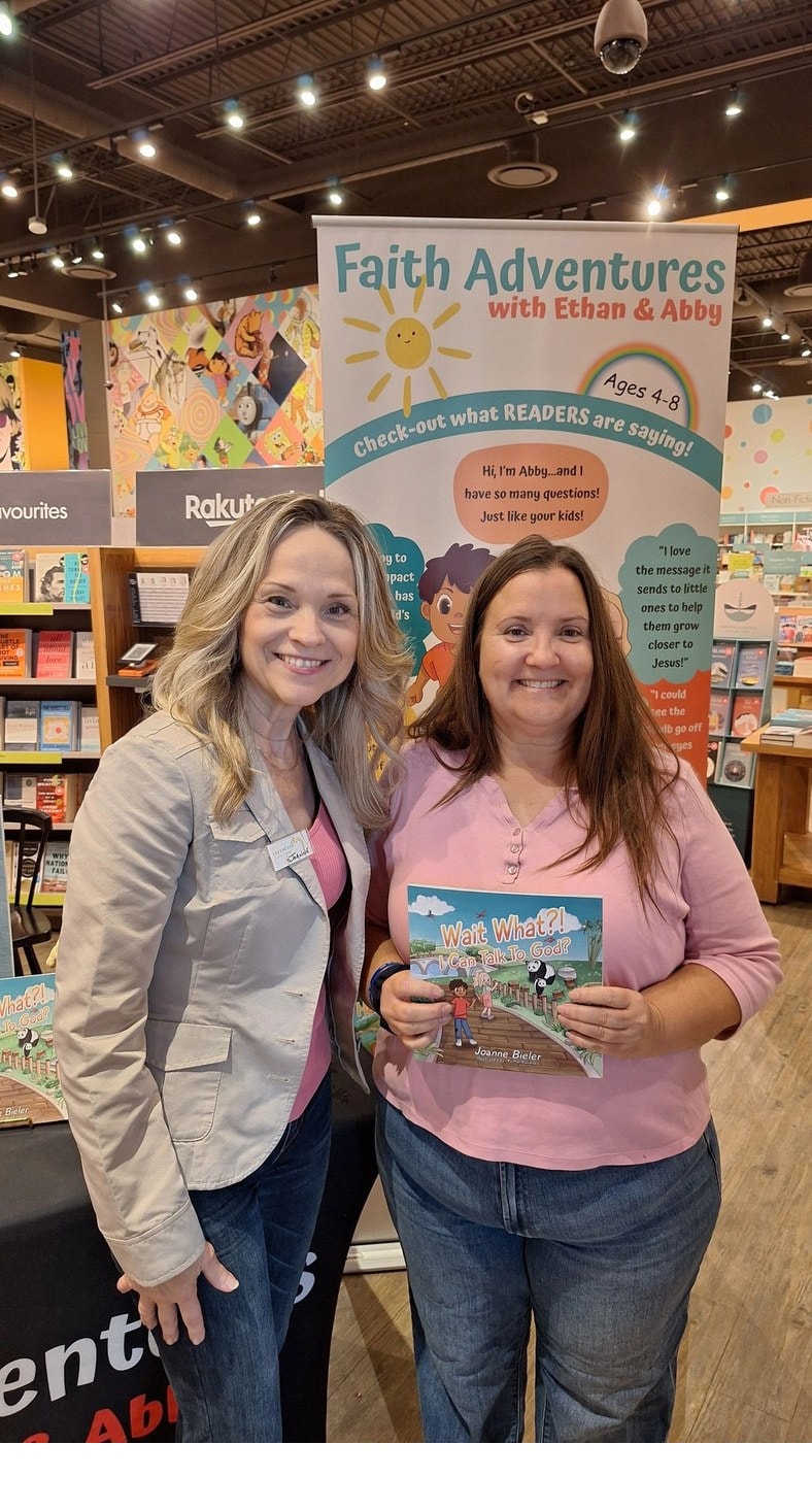 Joanne and a reader holding Wait What?! I Can Talk To God? at Indigo Erin Mills bookstore