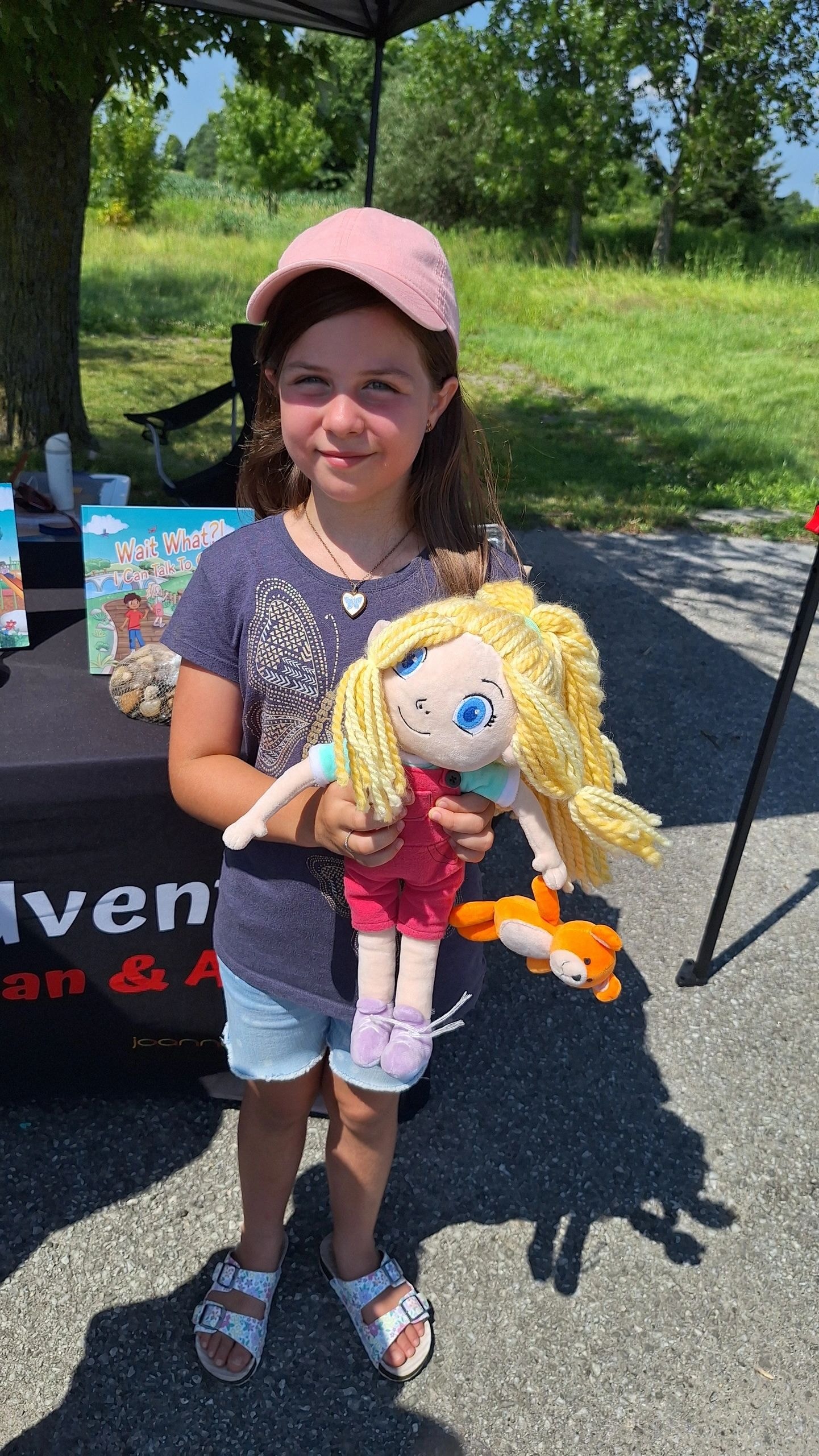Young girl Valerie holding the Abby doll at the Niagara Falls Christian Music Festival outdoor booth