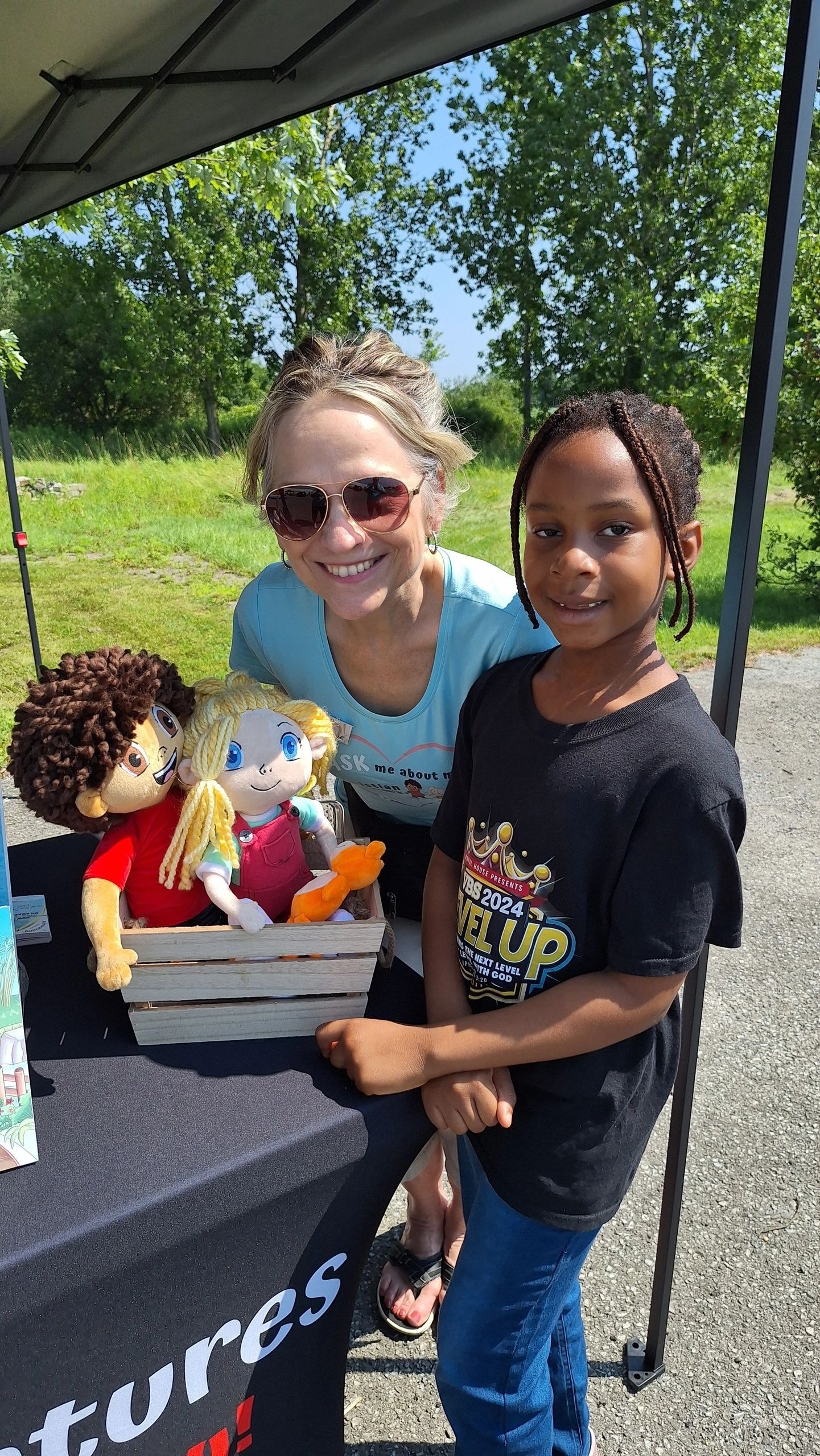 Joanne and a young boy with Ethan and Abby plush dolls at the Niagara Falls Christian Music Festival